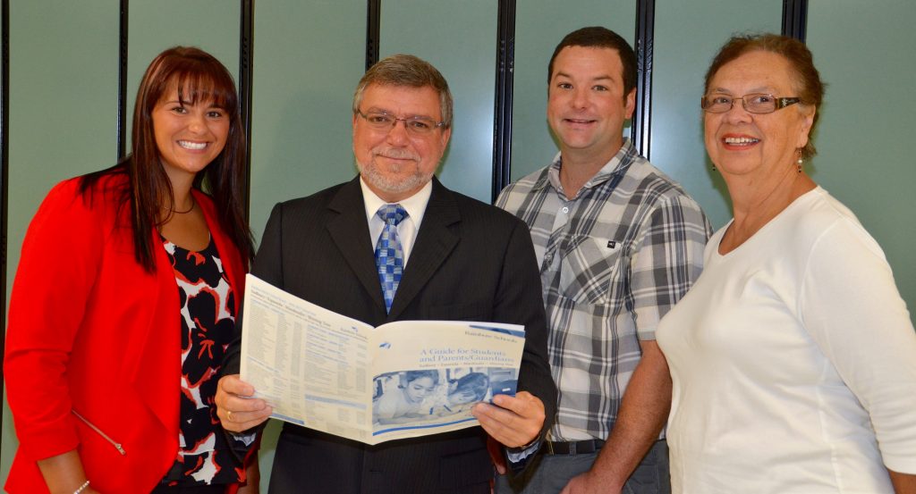 An image of Director Blaseg holding a copy of the Guide for Students and Parents/Guardians will staff members