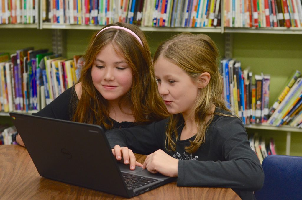 An image of two students working on a Chromebook