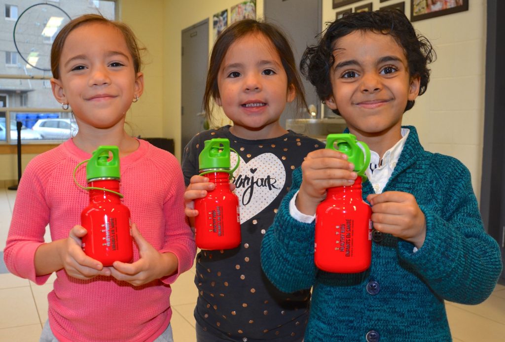 An image of three students holding water bottles