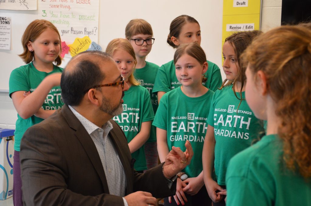 An image of Energy Minister speaking with students
