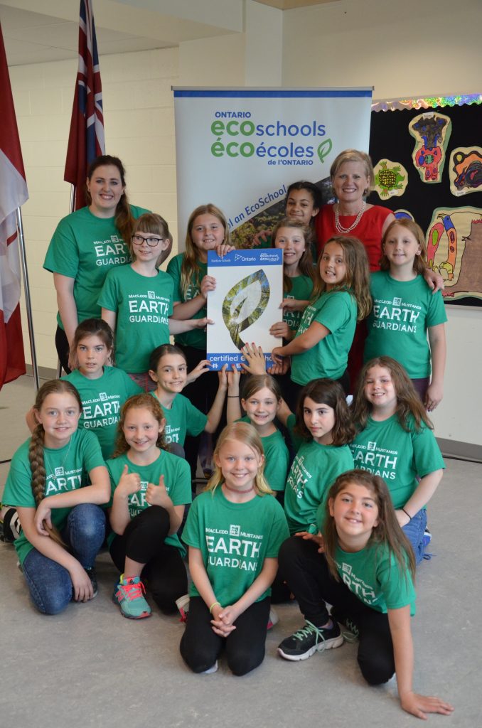 An image of students in front of the eco schools banner