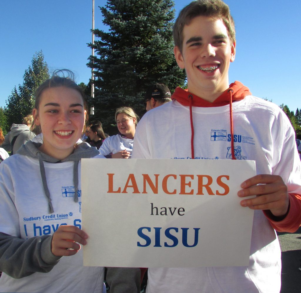 An image of two students holding a sign