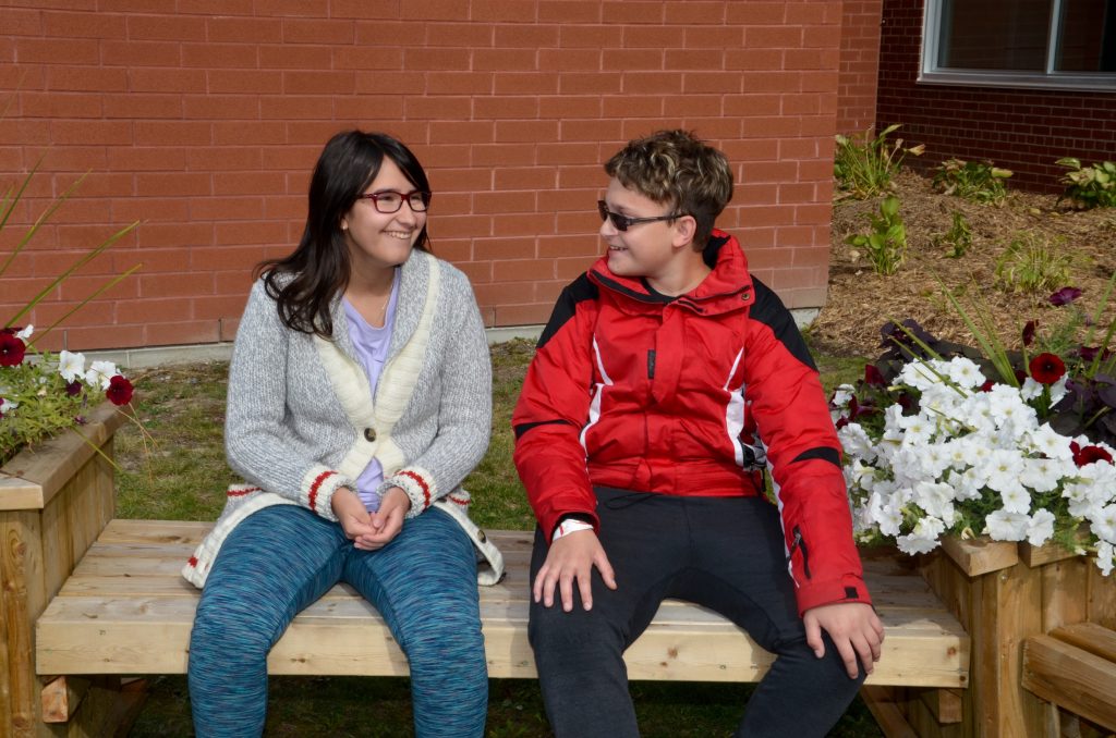 An image of two students enjoying the outdoor classroom at Sudbury Secondary School.