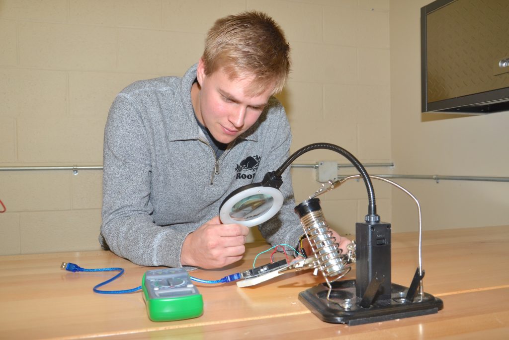 A student observing a motherboard