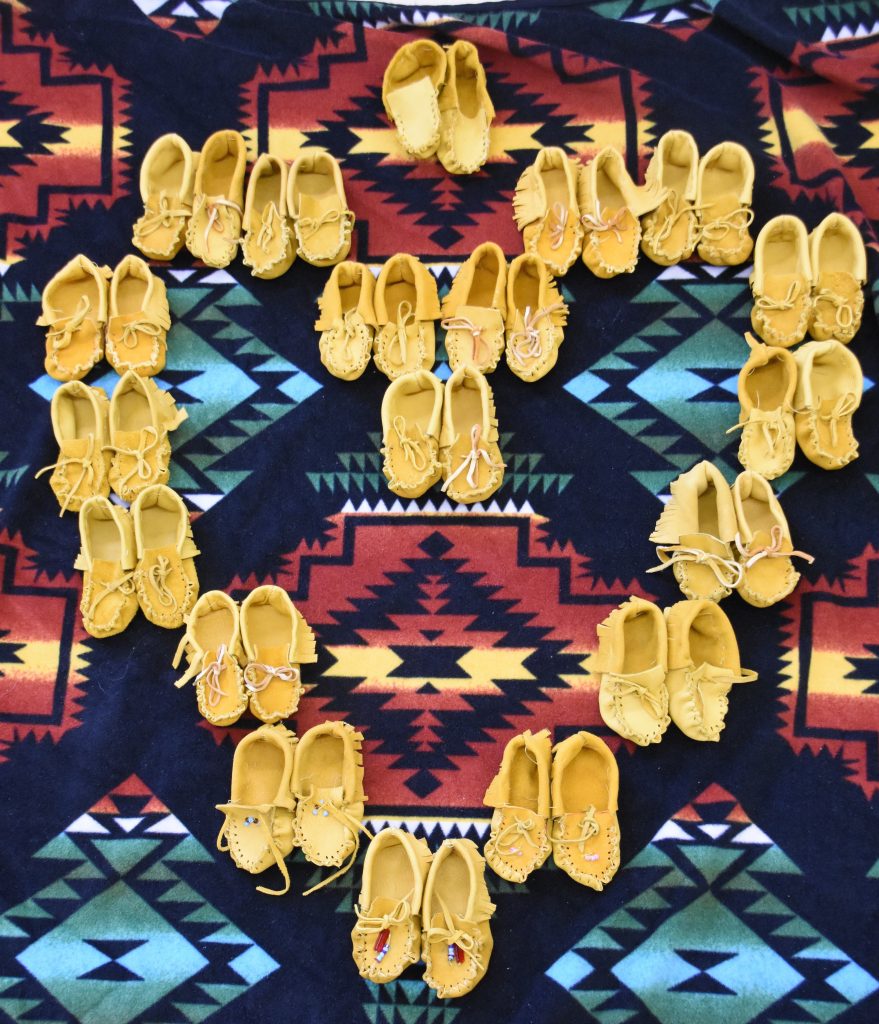 An image of moccasins laid out in the shape of a heart