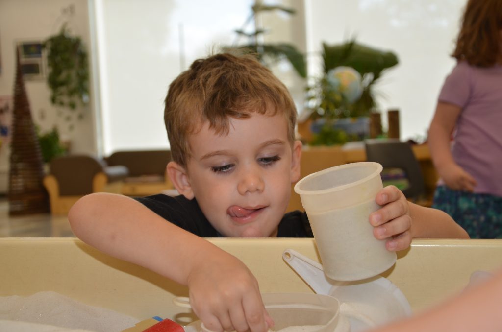 Axel Burton measures and mixes in the sandbox during the Kindergarten Camp at Algonquin Road Public School.