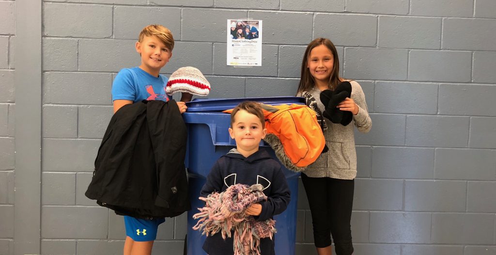 From left, Hayden Barton, Easton Sirkka and Sabrina Nootchtai of R.H. Murray Public School invite the community to drop off gently used winter clothing to any Rainbow School. The clothing will be redistributed to make this winter a little warmer.