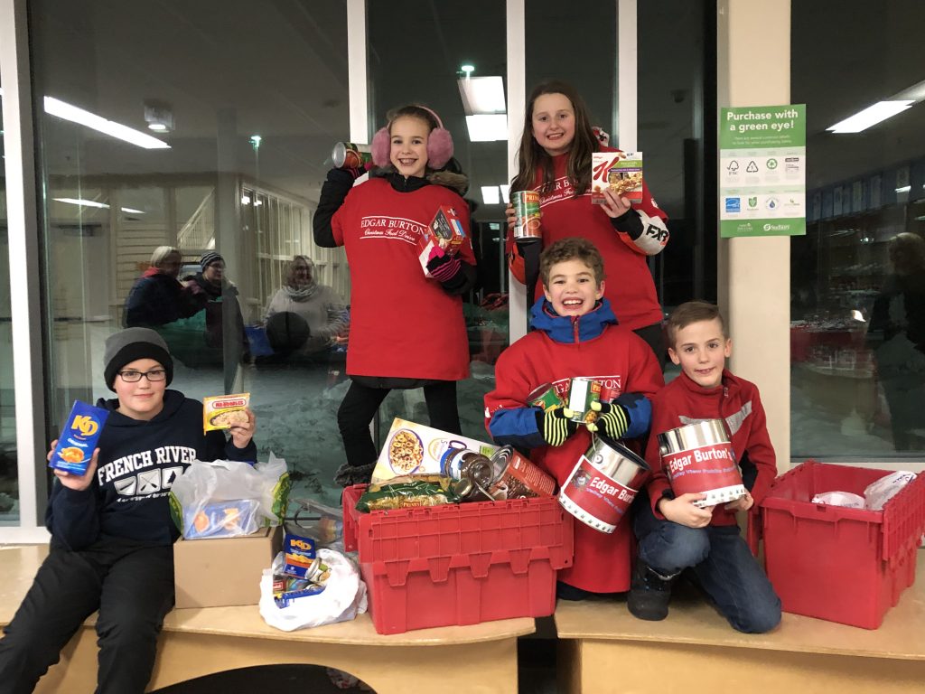 Students holding canned food