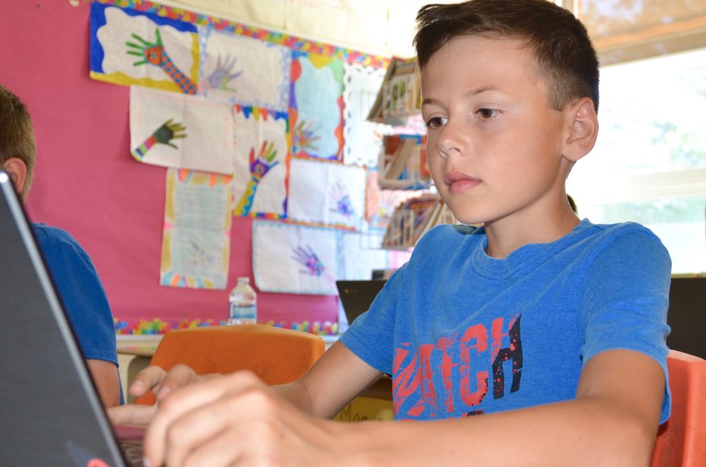 R.L. Beattie Public School student Jacob Paille completes an in-class assignment using a laptop.