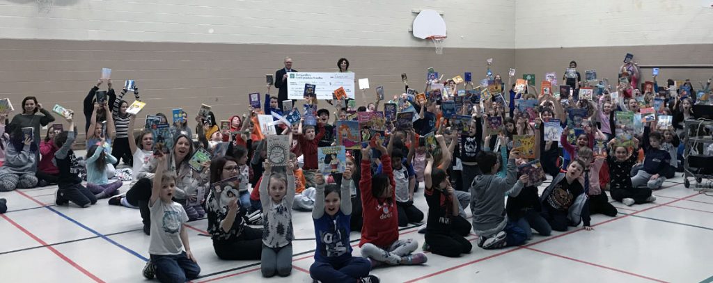 Students holding up books