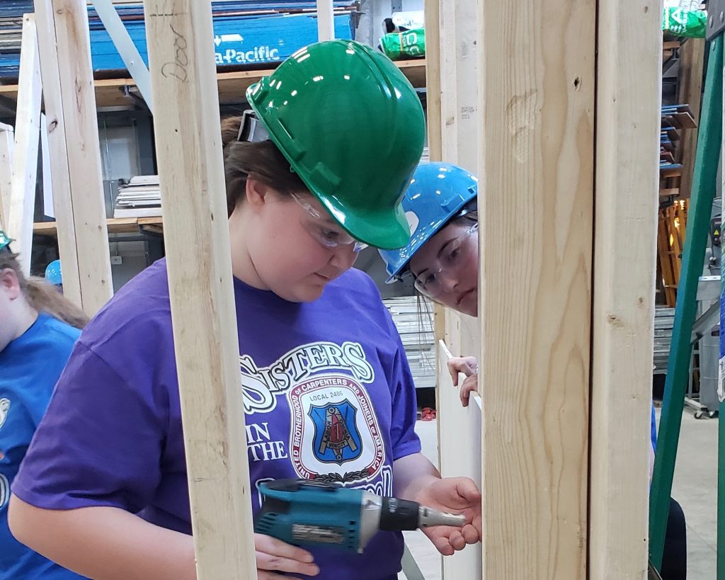 A student learning how to drywall