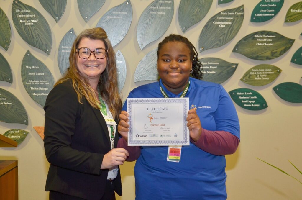 Nureein Bakr of Sudbury Secondary School, right, receives a Certificate of Internship from Nicole Leclair, Director of Long-Term Care Services with the City of Greater Sudbury. Nureein Bakr is one of ten students from Rainbow Schools participating in Project SEARCH Pioneer Manor for 2026-2027.